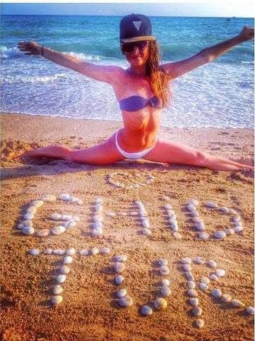 A traveller beside GhidTur spelled in shells on the beach.